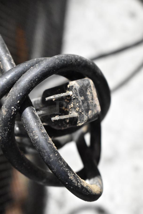 Close-up of a dusty power cord for an Arctic Air Stainless Steel Commercial 2 Door Reach In Freezer, 115 Volts, 1 Phase.