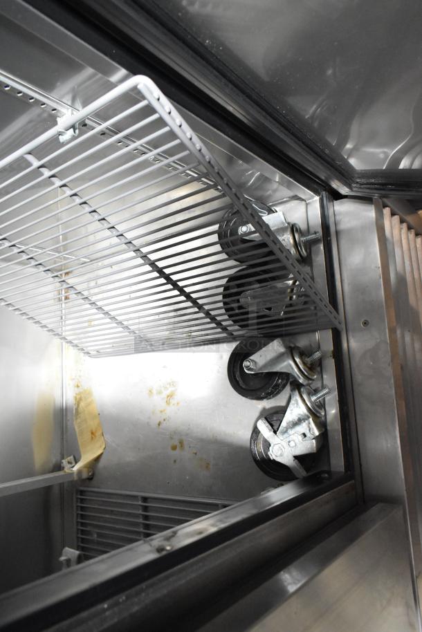 2017 True T-35 stainless steel 2-door reach-in cooler interior with poly-coated racks, visible commercial casters.