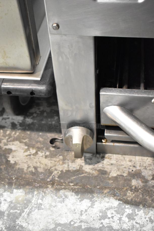 Standard Range stainless steel commercial cheese melter, knob and handle detail, shows signs of use.