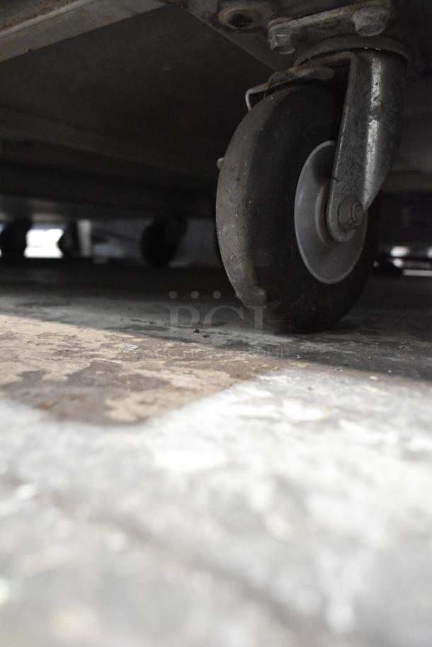 Dinex Carlisle ICTPT-24 metal pan transport rack caster detail, showing sturdy commercial wheel construction.
