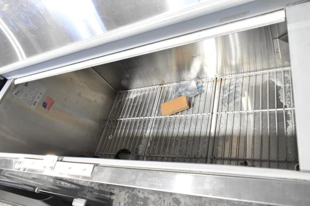 Norlake AR122SSS/0-A stainless steel milk cooler, interior view with wire rack, American flag label, 208-230V, 1-phase.
