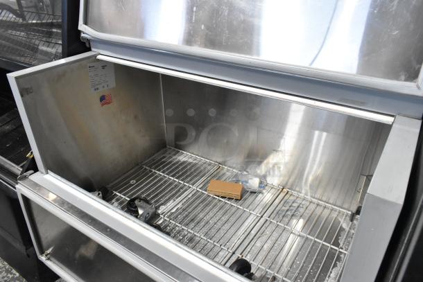 Norlake AR122SSS/0-A stainless steel commercial milk cooler, features wire shelving, open storage space, and visible label.