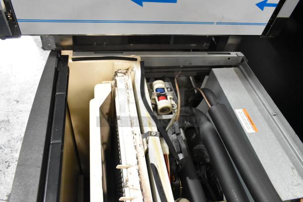 Manitowoc SY1204A stainless steel commercial ice head, 208-230V, 1 phase, interior view showing components and condition.