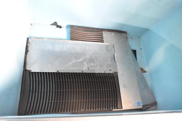 Manitowoc QY1305W metal commercial ice head on bin, used condition, 208-230V, 1 Phase. Visible wear, suitable for business use.
