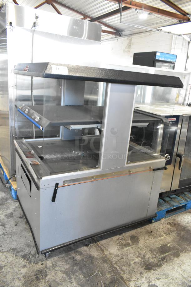 Custom Deli's 2-tier metal warming display merchandiser on commercial casters, good condition, features transparent sides.