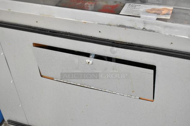 Custom Deli's 2-Tier Metal Warming Display Merchandiser on casters, showing used condition, slight wear visible.