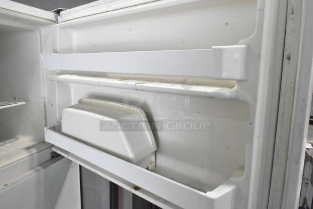 Maytag M1TXEGMYW00 metal reach-in cooler with freezer, interior view showing moderate wear, 115 volts, 1 phase.