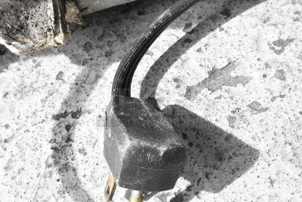 Close-up of a power plug for a Whirlpool WZC3115DW00 chest freezer, showing wear and minor dirt.