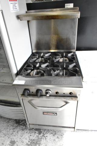 Tri-Star stainless steel commercial 4-burner gas range with oven, over shelf, and back splash. Signs of use, durable build.
