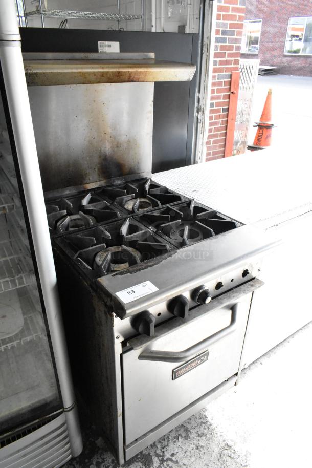 Tri-Star stainless steel commercial 4-burner gas range with oven, over shelf, and backsplash in used condition. Item tag visible.