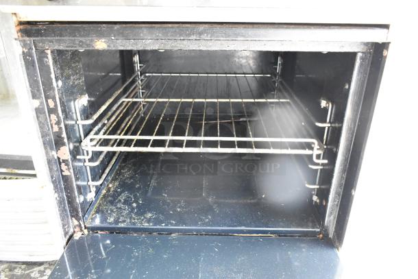 Tri-Star stainless steel commercial gas 4-burner range with oven, over shelf, and backsplash. Oven interior with visible wear.
