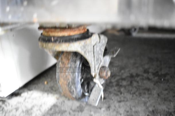 Close-up of a rusty caster on the base of a Turbo Air MST-60-24 commercial prep table, indicating wear and age.