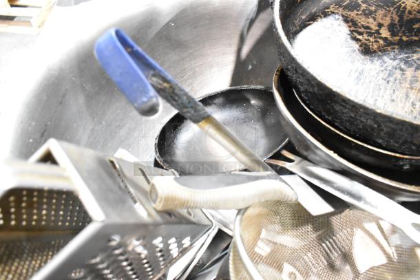 Lot of kitchen items including scratched skillets, metal bowl, grater, and utensils. Mixed condition.