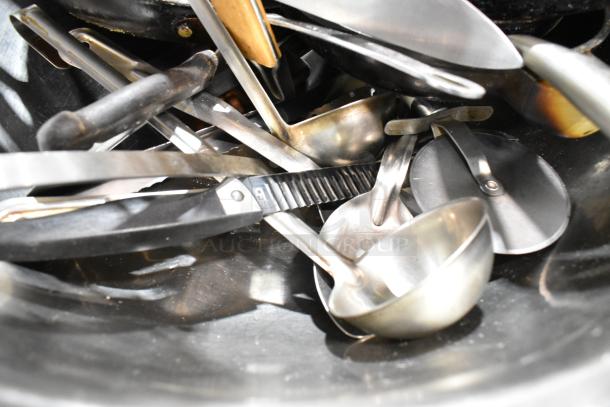 Lot with spice rack, skillets, metal bowl, and kitchen tools. Mixed condition, includes tongs and ladles.