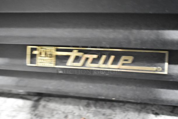 True GDM-41SL-54EM-LD cooler tag, gold lettering on a black background, indicating True as the manufacturer.