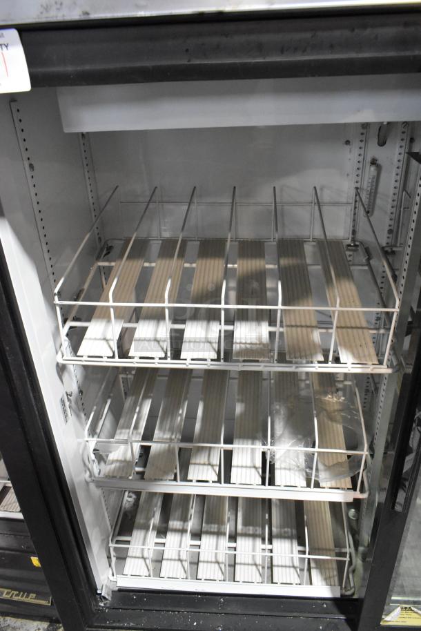 True GDM-41SL-54EM-LD metal commercial cooler with two glass doors, poly coated racks, 115 volts, 1 phase. Clean interior.