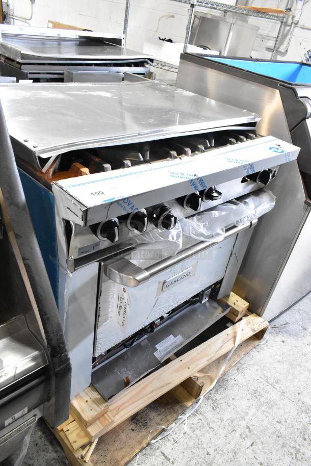 Garland 372G366CN stainless steel 6-burner range with convection oven, overshelf, backsplash. Brand new, scratch and dent, 236,000 BTU.