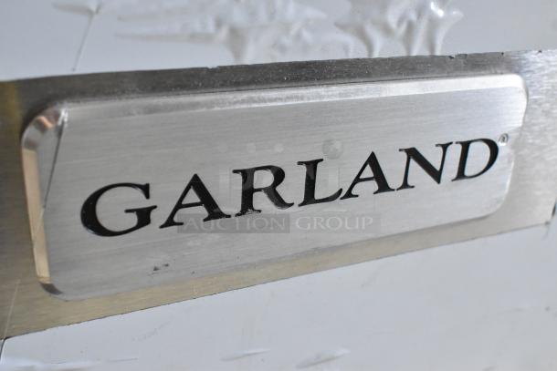 Garland logo on stainless steel panel, part of a commercial 6 burner range oven, model 372G366CN, natural gas powered.