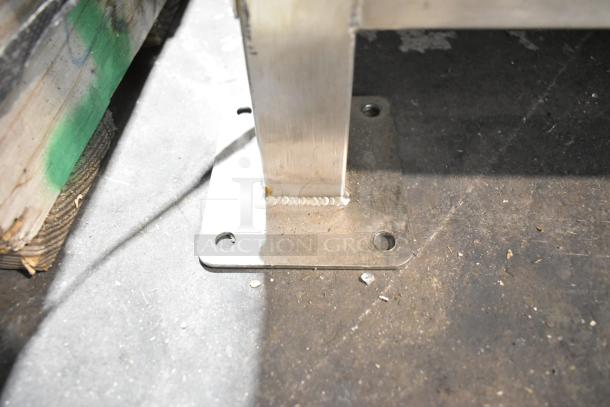Base of Champion Tuff 782TG60 stainless steel wood-burning grill, showing secure metal welds and mounting plate.