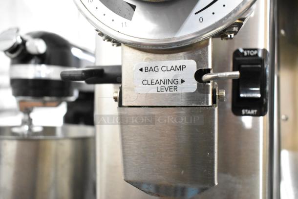 Bunn GVH stainless steel coffee grinder without hopper; features bag clamp and cleaning lever. Scratch and dent condition. 120V.