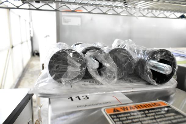 Plastic-wrapped components on top of a labeled surface, possibly parts for a Bunn SINGLE AXIOM 15 coffee machine.