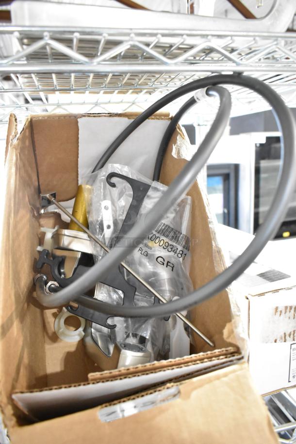 Box containing new Delta Faucets, including electronic touchless and stainless finish models with accessories.