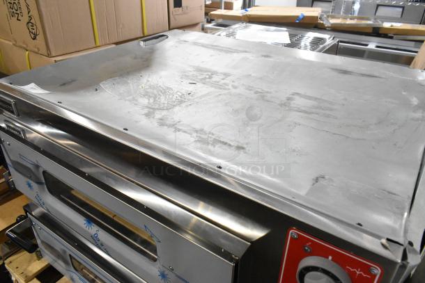 Brand new Trento stainless steel countertop pizza oven, 2 decks, cooking stones, 230V, minor scratches and dents visible.