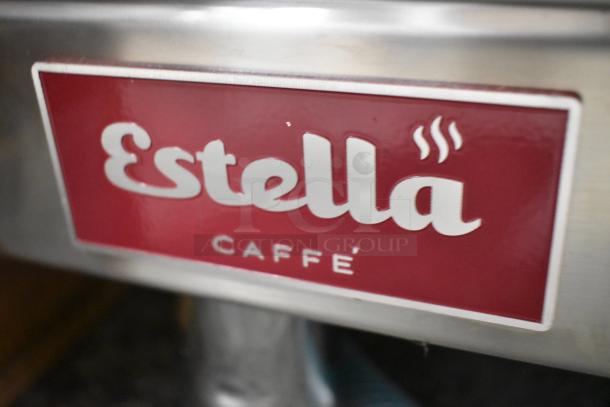 BRAND NEW Estella ECEM2 stainless steel commercial espresso machine, two group, auto, 2 portafilters, 2 steam wands, 1 leg defective.