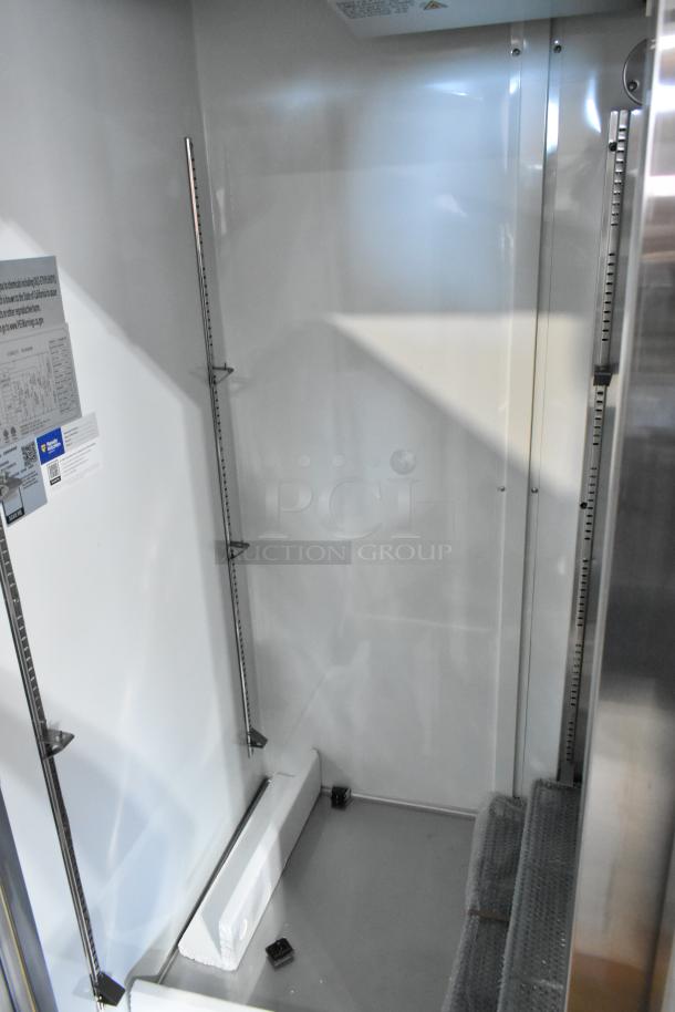 Stainless steel interior of Mainstreet 829BMR49F commercial 2-door reach-in freezer. New condition with visible shelf brackets.