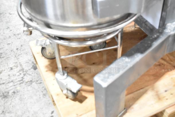 Avantco 177MX60H 60 Qt. metal dough mixer base with wheels on wooden pallet, featuring bowl dolly and part of bowl visible.