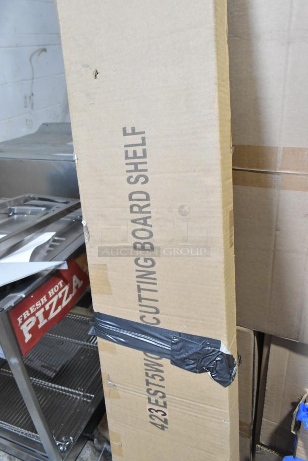 Cardboard box labeled "423EST5WOPB CUTTING BOARD SHELF" taped shut; item inside not visible.