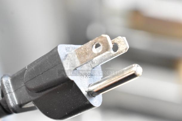Close-up of a standard two-prong electrical plug from a Summit wine cooler model STC12.