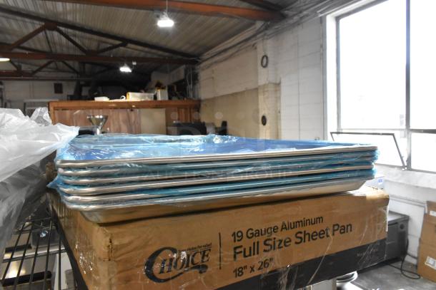 15 brand new scratch and dent Choice 18"x26" aluminum sheet pans, 19 gauge, stacked on a labeled box.