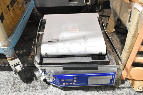 Brand new Globe GSG14D stainless steel sandwich grill, 14" x 14" smooth plates, 120V. Scratch and dent condition. Auction tag visible.