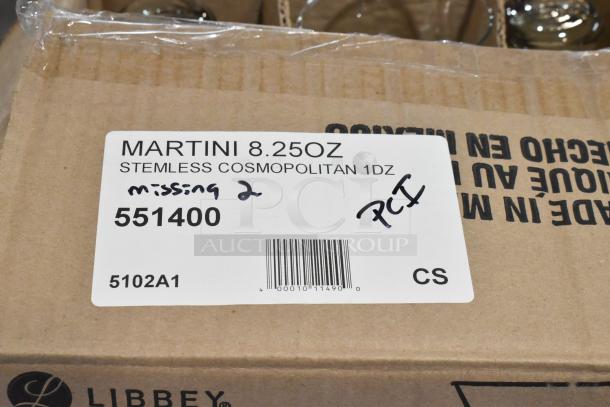 Auction image showing a labeled cardboard box for Libbey Martini 8.25 oz Stemless Cosmopolitan glasses. Handwritten notes: "missing 2" and "PCI."