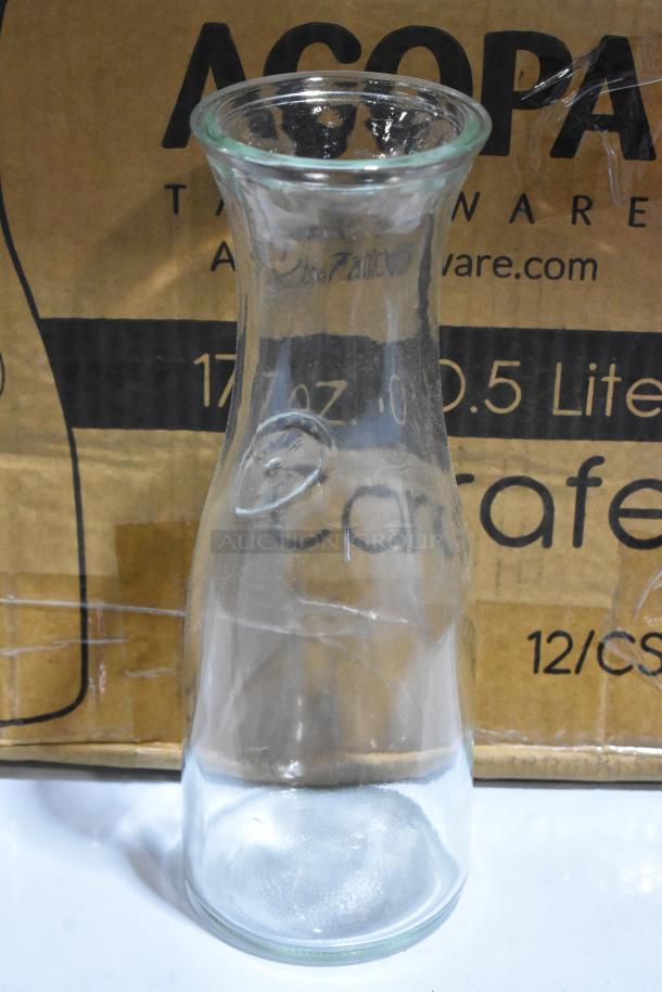 Acopa 17 oz. glass carafe, new condition, in front of original packaging box.