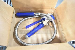 Brand new spray nozzle attachment in a box, blue handle, flexible metal hose, some surface scratches visible.