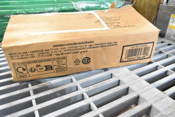 Cardboard box with AmazonBasics spray nozzle attachment, "Made in USA" label. Box has visible scratches and dents.
