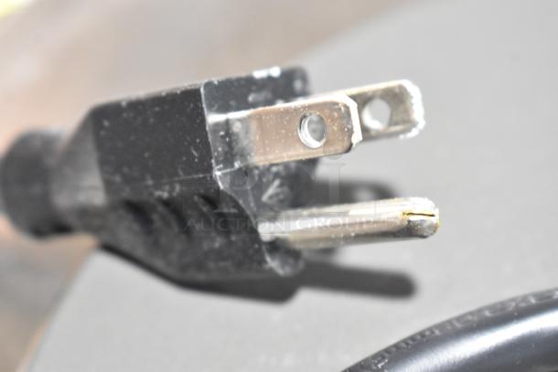 Close-up of a power plug for the 2025 Nemco 6310-1 electric countertop hot plate, 120V, showing minor scuffing.