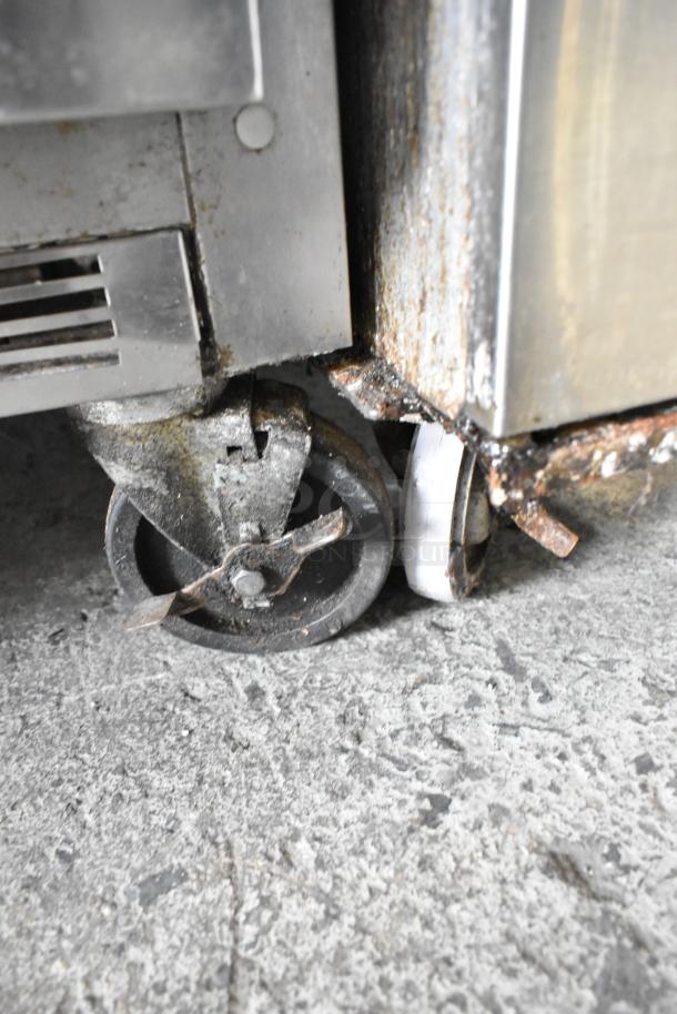 Beverage Air UCFD36AHC-2 stainless steel undercounter freezer on commercial casters, showing wear and rust on wheels.