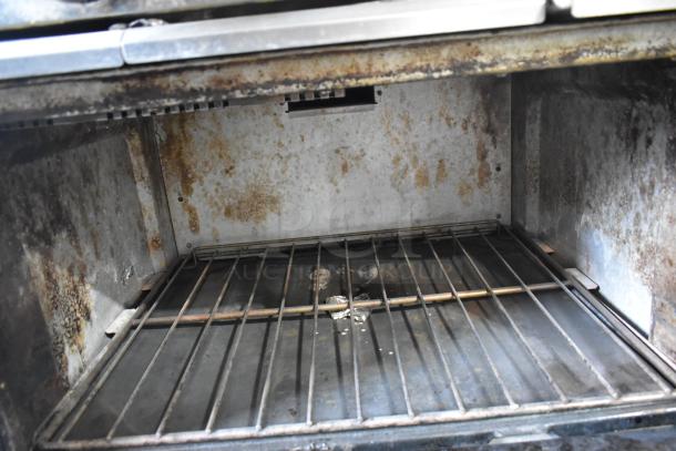 Garland X36-6R SunFire stainless steel oven interior, showing wear and discoloration. Racks in place, suitable for commercial use.