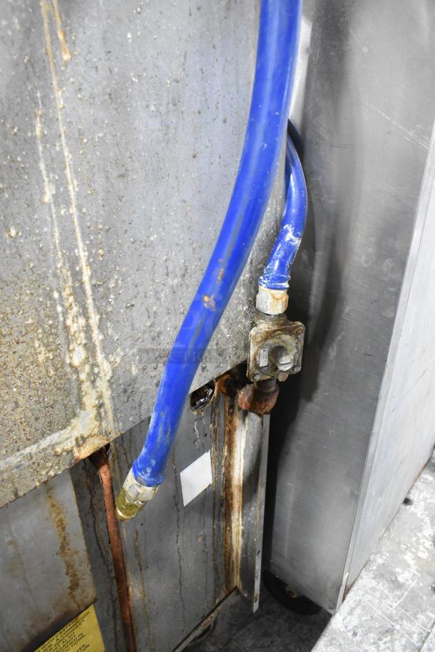 Back view of Garland X36-6R range showing a blue gas line connection and visible rust, indicating wear and maintenance needs.