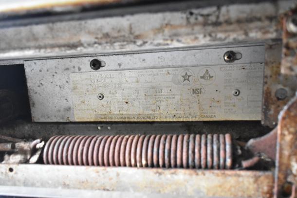 Corroded label of Garland X36-6R range, indicating NSF certification and natural gas power.