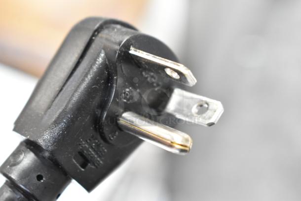 Close-up view of a three-prong electrical plug, indicating compatibility with 208/240V outlets for a Solwave microwave.