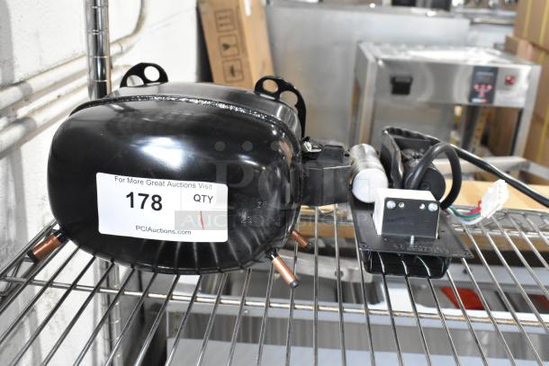 Brand new Secop SCE21CNLX motor, 115V, 1 phase, scratch and dent, auction tag number 178 visible.