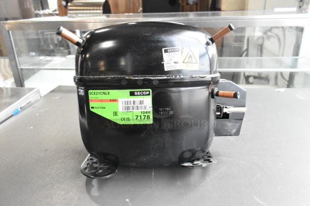 BRAND NEW Secop SCE21CNLX Motor, 115V, 1 Phase, visible scratch and dent, green label with model details.