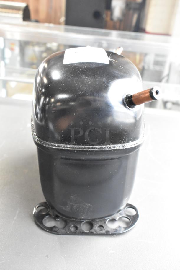 BRAND NEW scratch and dent Secop SCE21CNLX motor. 115V, 1 Phase. Black with copper piping, visible label on top.