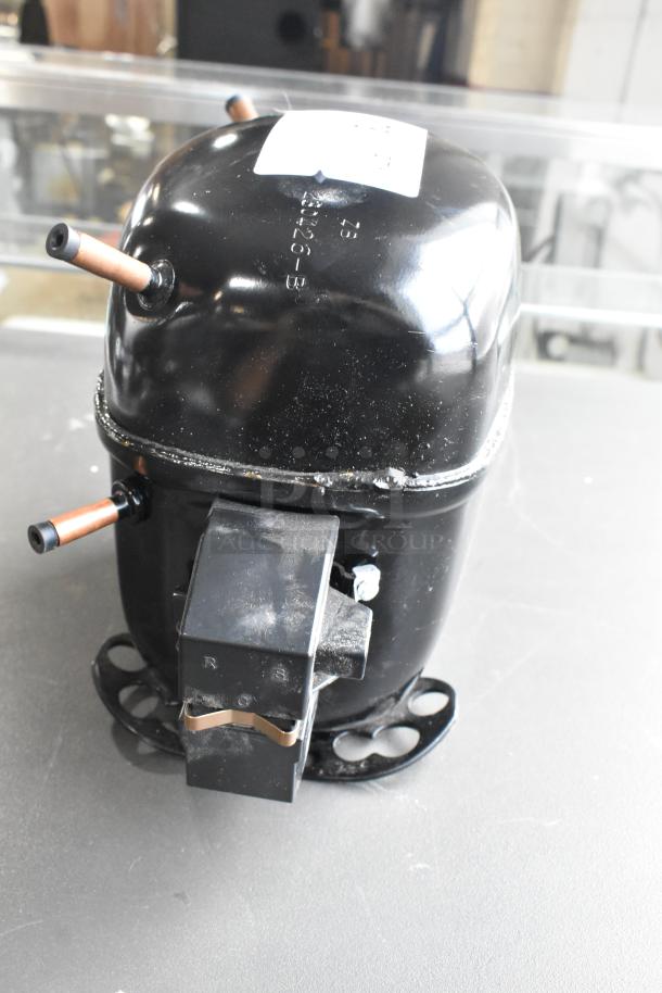 BRAND NEW SCRATCH AND DENT Secop SCE21CNLX Motor, 115V, 1 Phase, black exterior, visible markings, minor cosmetic damage.