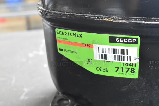 BRAND NEW SCRATCH AND DENT Secop SCE21CNLX Motor, 115V, 1 Phase. Green label with R290, suction mark, and barcode visible.
