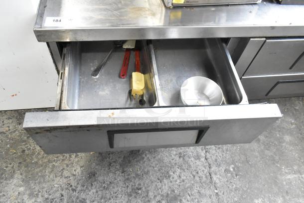 True Stainless Steel Commercial 4 Drawer Chef Base, 115 Volts, 1 Phase, on casters, used condition with utensil storage.